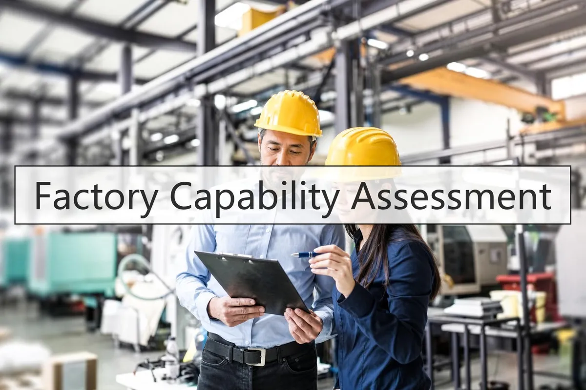 Two auditors in hard hats reviewing an audit checklist on a factory production floor