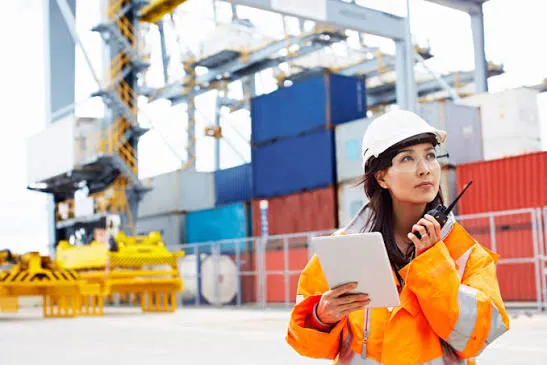 Port coordinator with a tablet and radio signing off a shipment release