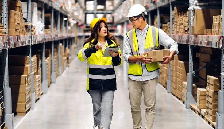 Warehouse team reviewing a damage claim with a tablet and a carton