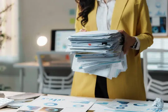 A team member holding the printed order file, including inspection and shipping documents